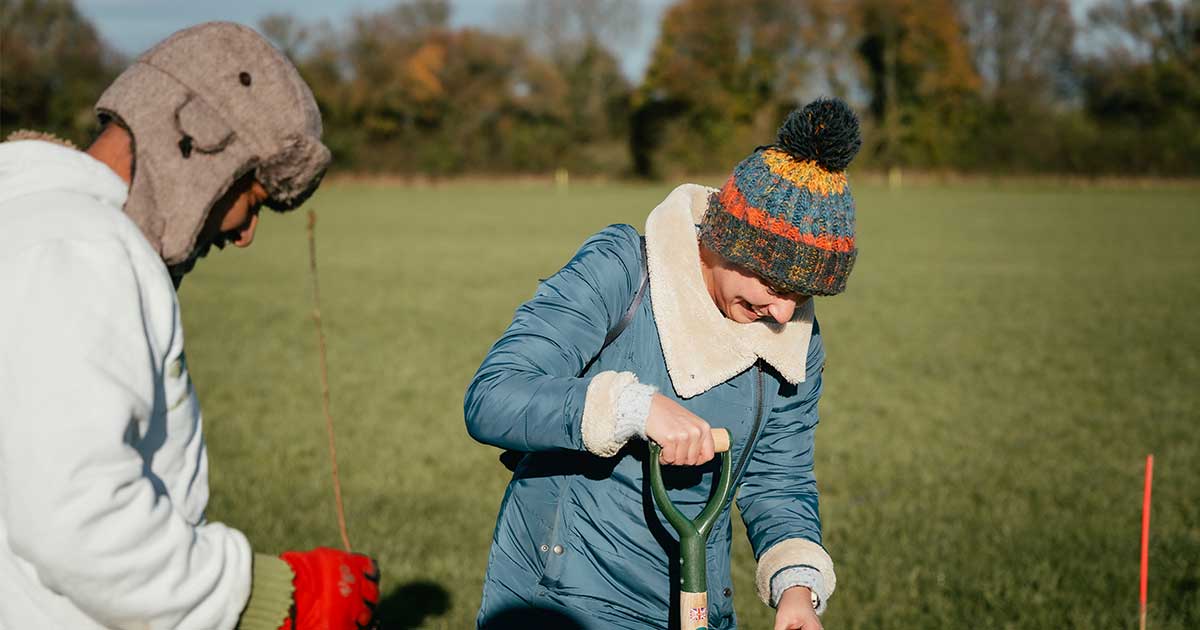 Two people planting trees at volunteer day.