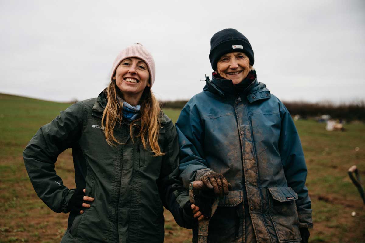 Two women smiling at a tree planting day.